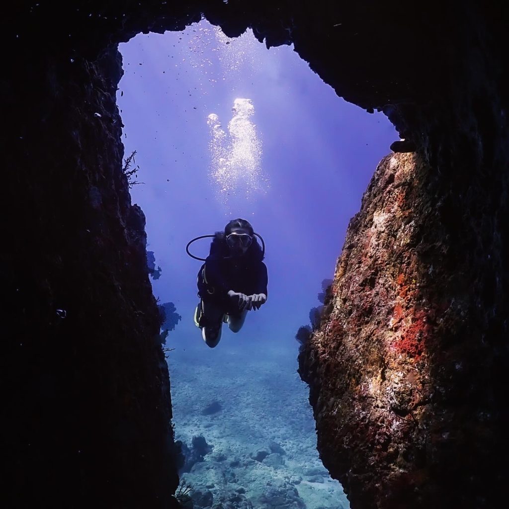 diver-swimming-through-an-arch